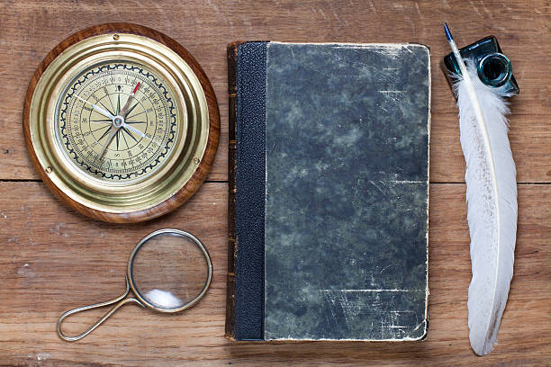 istock Compass, book, magnifying glass, quill and inkwell on wood 177322461