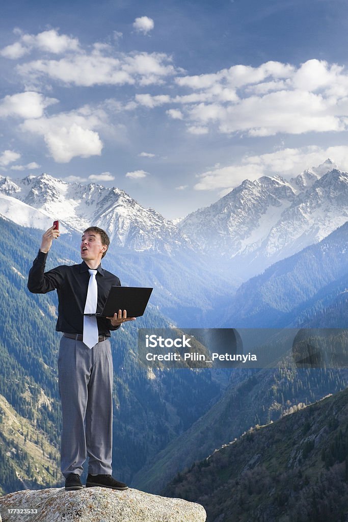 Junger Geschäftsmann mit seinem laptop und Mobiltelefon - Lizenzfrei Alpen Stock-Foto