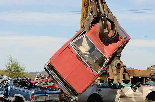 Large lift truck moving crushed cars at a metal recycle yard