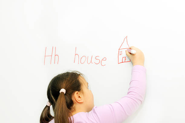 istock Smiling schoolgirl learning to write letter H 177324979