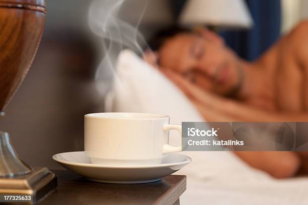 Man Sleeping On Abed A Cup Of Hot Tea Stock Photo - Download Image Now - Adult, Apartment, Bed - Furniture