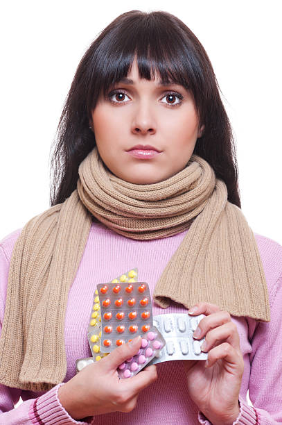 istock young woman holding pills 177325871