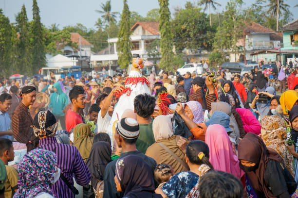 yogyakarta, indonesia, october 29, 2023
traditional celebration, crowds of people jostling scramble to pick up mountain-shaped fruit and vegetables is called 