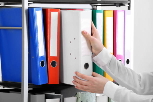 istock Woman taking folder with documents from shelf in office, closeup 1773271195