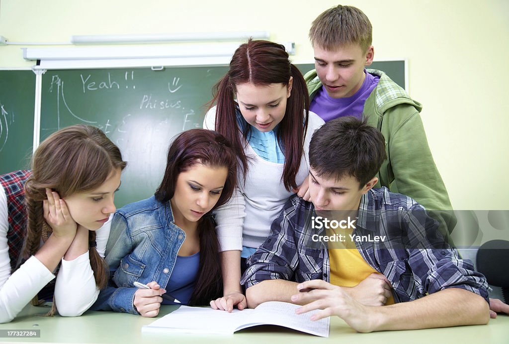 five students in classroom Group of  five  students discussing in classroom Adolescence Stock Photo