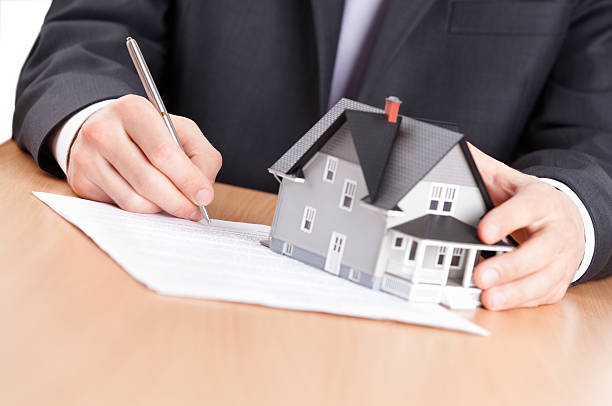 istock Business man signs contract behind household architectural model 177327534