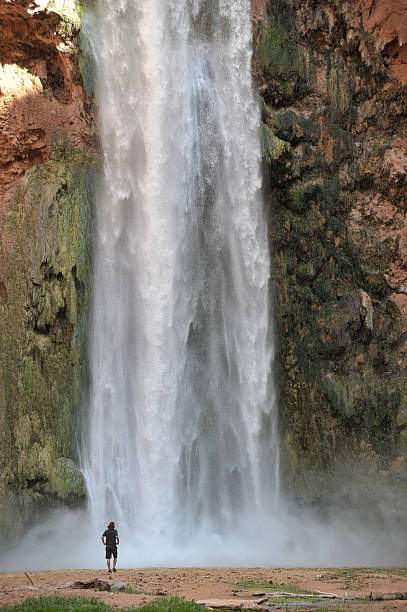 istock Man Stands at Bottom of Waterfall 177327923