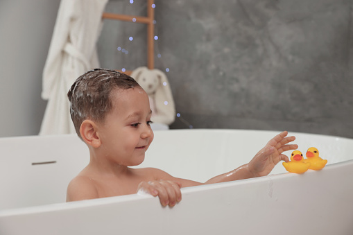 Children in bathtube washing hair