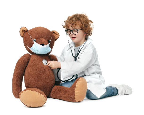 istock Little boy playing doctor with toy bear on white background 1773283873