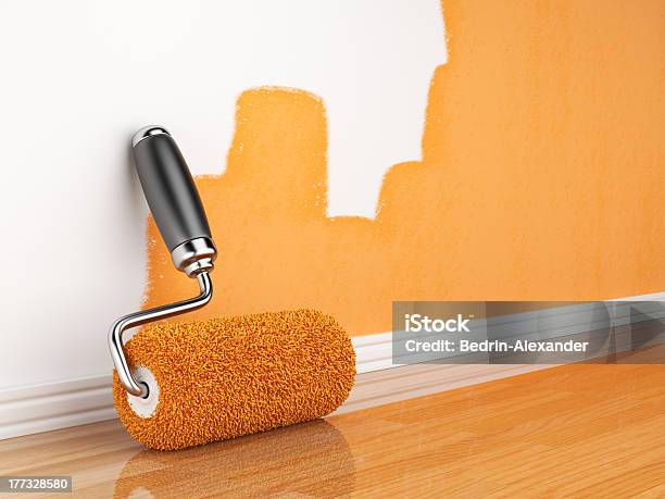 Incomplete Orange Wall Painting With Roller Leaning On Wall Stock Photo - Download Image Now