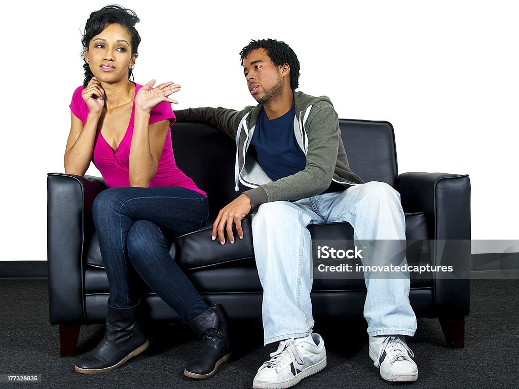 Black Male and Female Lovers Quarreling on the Couch lover's quarrel on a black couch and isolated on a white background Adult Stock Photo