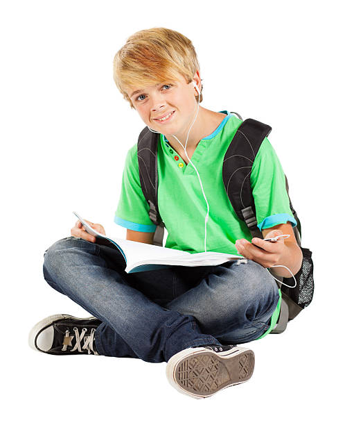 teen boy sitting on floor reading book
