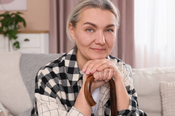 istock Senior woman with walking cane sitting on sofa at home 1773293810