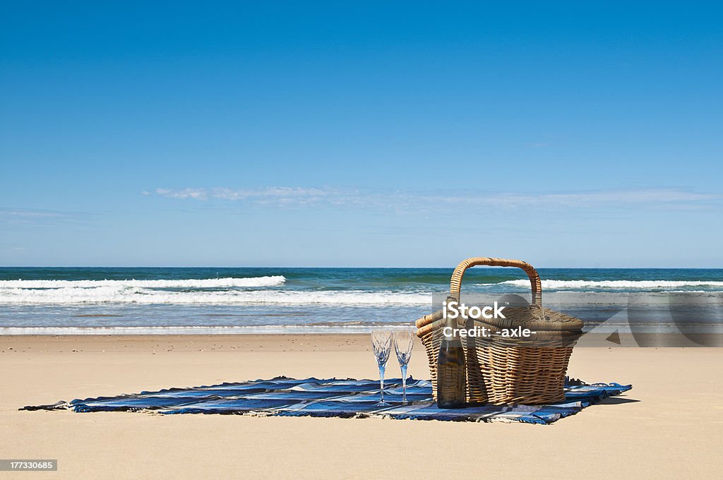 Celebrate in style. "Picnic blanket,champagne,picnic basket and a beautiful tropical beach." Beach Stock Photo