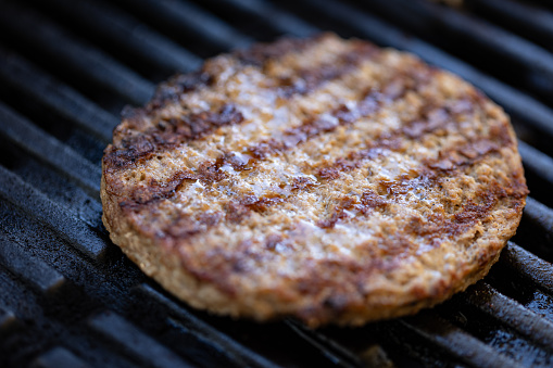 Close up of a burger on a grill grate