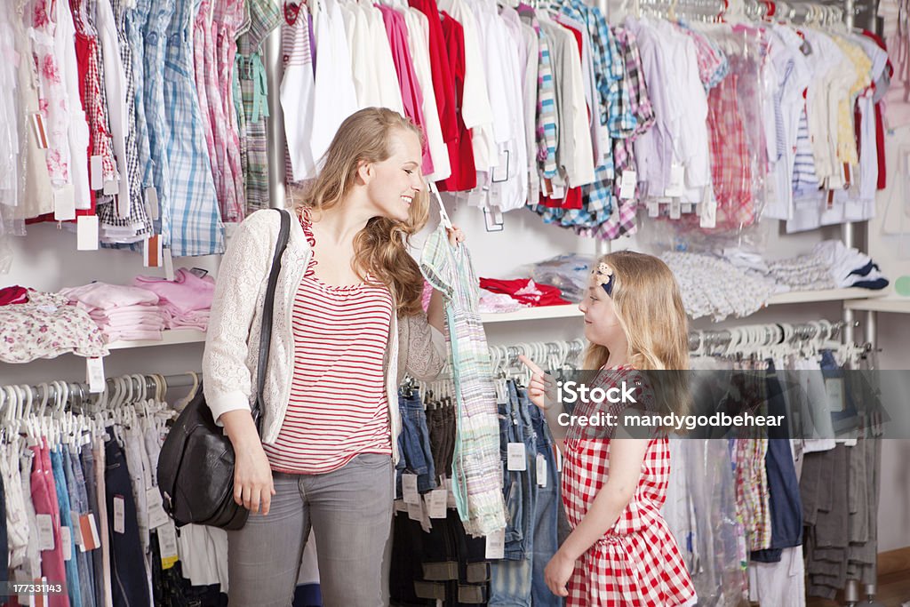 clothes shopping mother and child shopping choosing dress in clothes shop Child Stock Photo