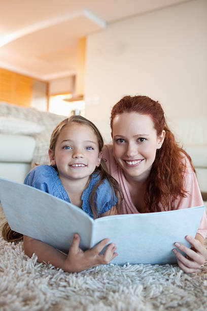 istock Mother and daughter with magazine on the floor 177332202