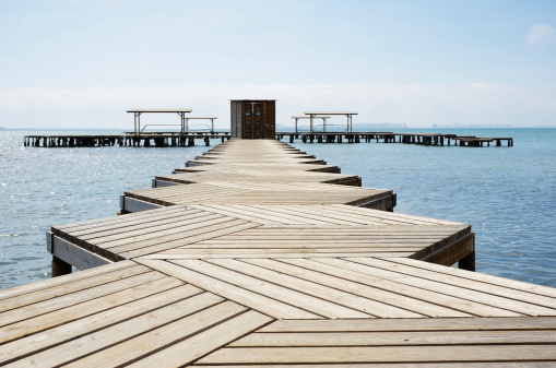 A planked platform recedes into the sea.