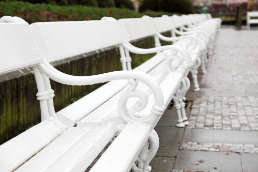 white benches posed on the sidewalk