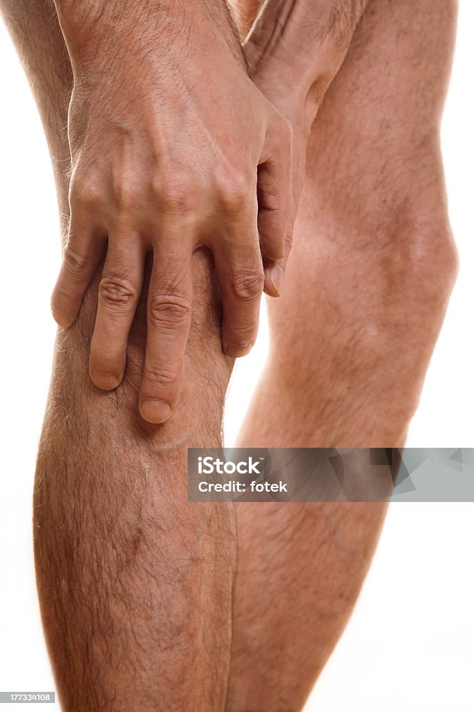 Close up of a man holding his knee Pain in a knee. Focus on right hand. Adult Stock Photo