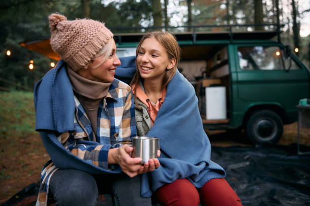 istock Happy mother and daughter talking while relaxing at camper trailer park. 1773348564