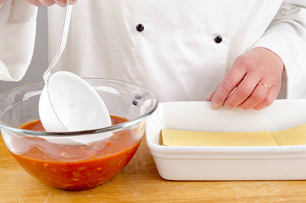 istock female chef with tomato sauce preparing lasagna 177334891