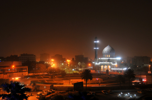 Shahid Mosque (where sunni muslims worship) at Firdos Square in downtown Baghdad by night. A sandstorm has colored the sky reddish.