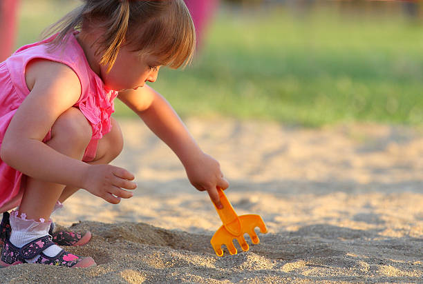 Girl plays on the beach with sand