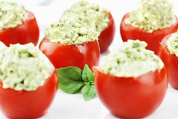 pesto y aguacate tomates rellenos - stuffed tomato fotografías e imágenes de stock