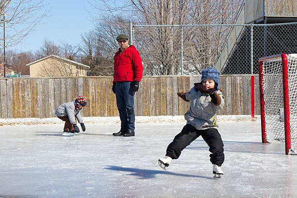 kleines mädchen fallen und eislaufen mit der familie - ice skating ice hockey child family stock-fotos und bilder