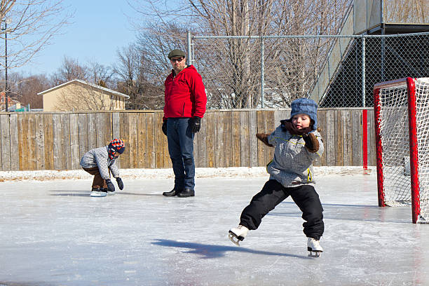 niña caer mientras de patinaje sobre hielo con la familia - ice skating ice hockey child family fotografías e imágenes de stock