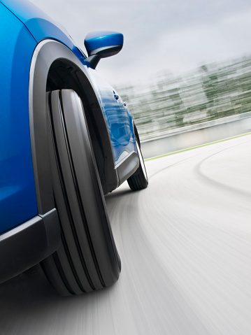 Low angle shot of front wheel while driving a car on the road in a curveSee more car driving images in my portfolio