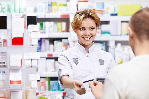 A person paying for an item in a pharmacy The pharmacist sells the medicine in a pharmacy in person purchasing meds stock pictures, royalty-free photos & images
