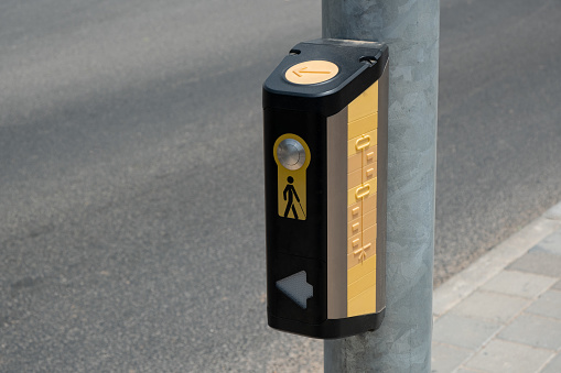 button, positioned at crosswalks.  tactile button, mounted on a pole, serves as an essential tool for blind individuals to safely cross the road
