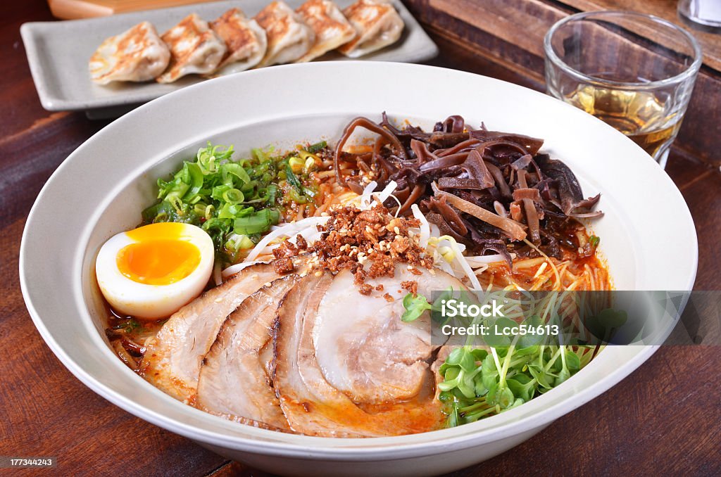 A big bowl of Ramen on a wooden table Japanese traditional ramen with other dishes on table      Ramen Noodles Stock Photo
