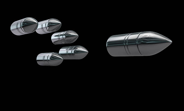 Bullets Flying bullets with reflections isolated on a dark background. Clipping path included for easy selection. Silver Bullet stock pictures, royalty-free photos & images