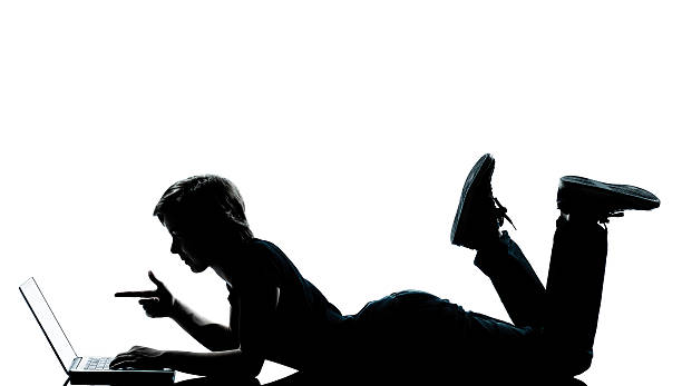 istock one young teenager boy  girl silhouette computer computing laptop 177345411