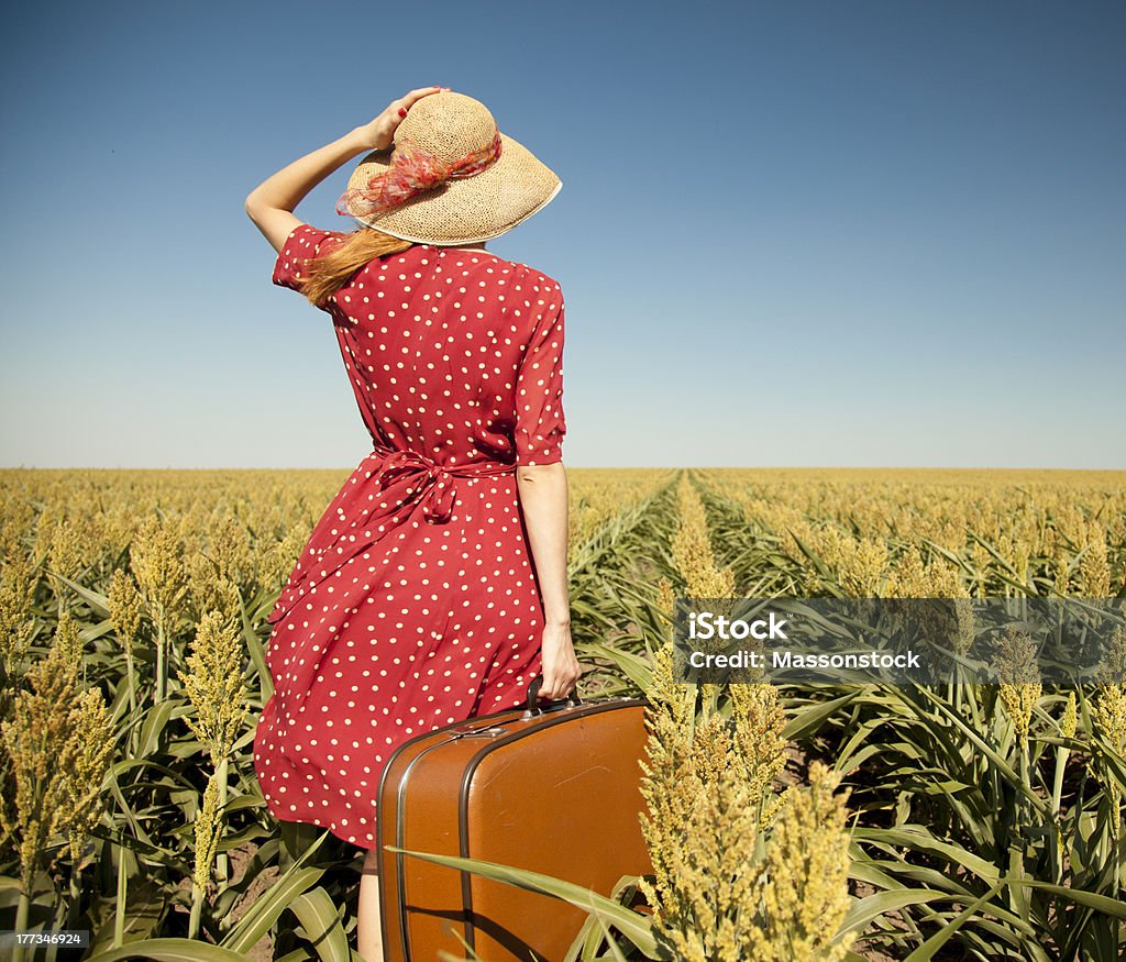 Redhead girl with suitcase at corn field. . Adult Stock Photo