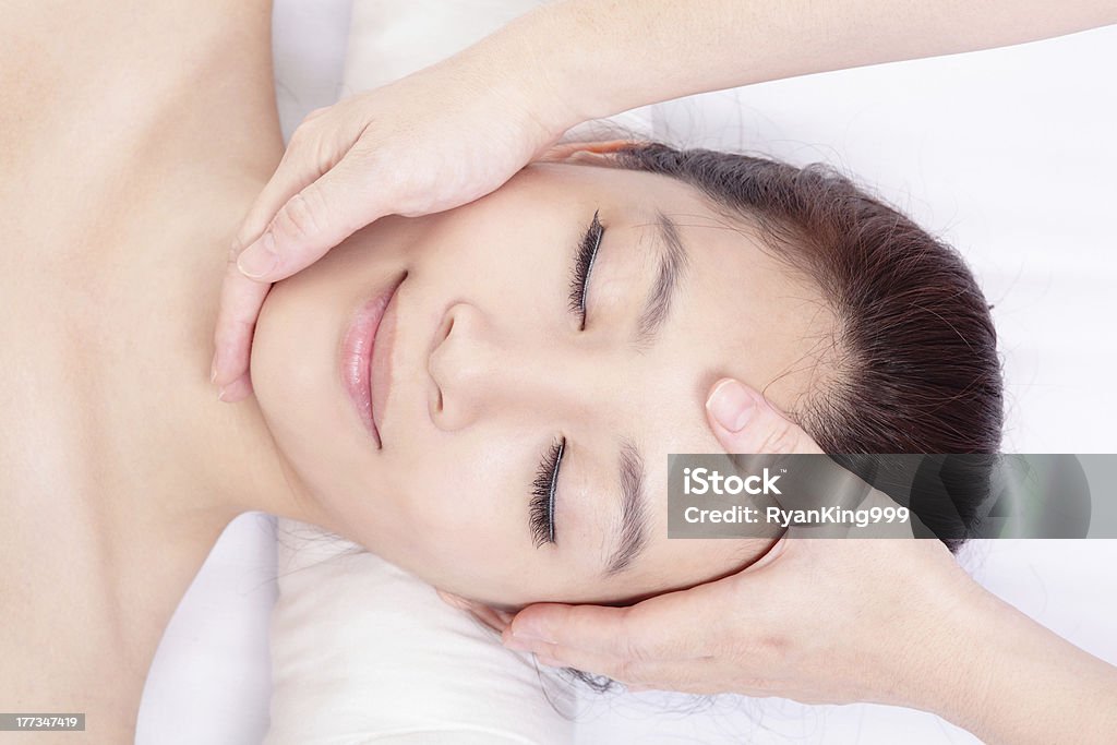 Donna godere ricevendo il massaggio del viso e testa - Foto stock royalty-free di Maschera per il viso