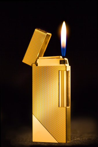 Elegant golden gas lighter against a dark background