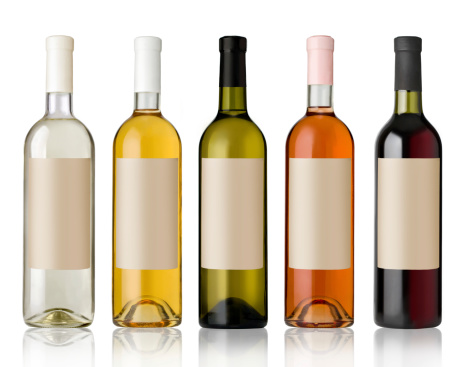 Close-up of five bottles of white wine isolated on white background, studio shot.