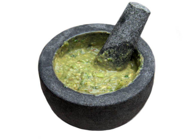 istock guacamole inside molcajete (traditional mexican mortar and pestle for grinding spices and making sauces) spicy avocado dip with aztec roots isolated on white background, cut out 1773490739