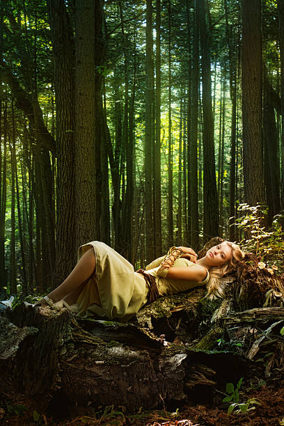 Blond girl dressed in dress walk in a magic forest