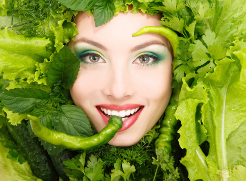 woman beauty face with greens vegetables and pepper frame isolated on white background