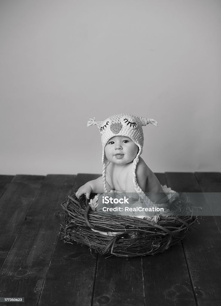 Bébé assis dans le nid d'oiseau portant chapeau - Photo de 6-11 mois libre de droits