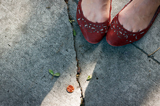 mädchen sieht einen penny auf dem bürgersteig stehen. - sidewalk walking human foot city stock-fotos und bilder