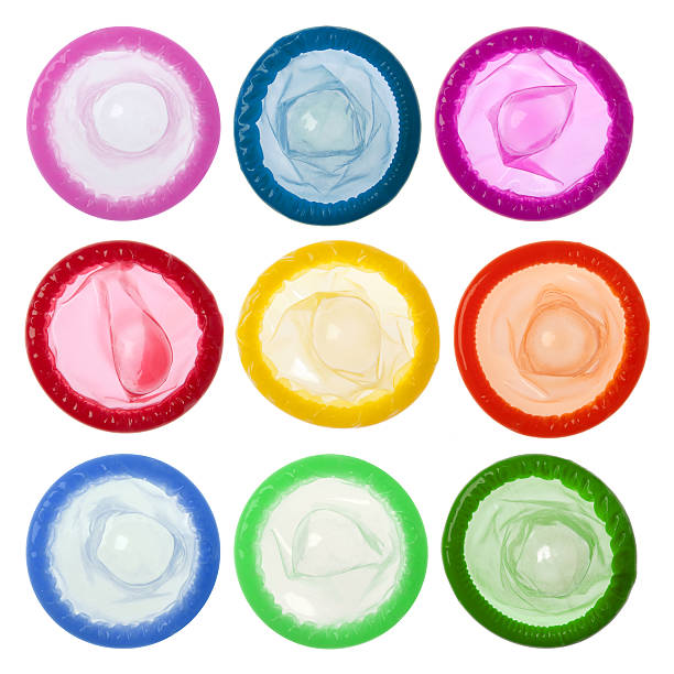 A row of different colored condoms Condoms isolated on white background  condom photos stock pictures, royalty-free photos & images