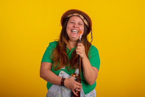Fat woman wearing a cangaceiro hat and holding a shotgun in reference to the Festa Junina in Brazil