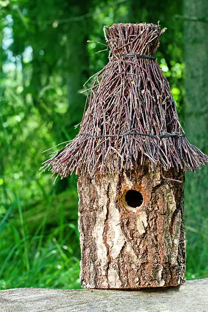 Decorative wooden handmade nesting box / birdhouse in green summer background