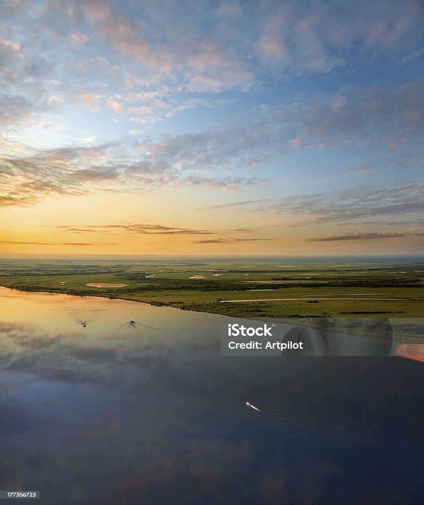 Ships on the great river during sundown Ships are on the great river during white nights. On the river is calm now. A boat cuts through the waters of the great river. Aerial View Stock Photo